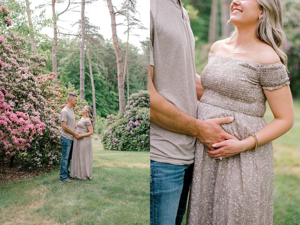 A Schoepfle Gardens maternity session by Brittany Serowski Photography of an expecting mother and father cuddled together holding the pregnant mothers belly while standing next to a pink flowering tree.