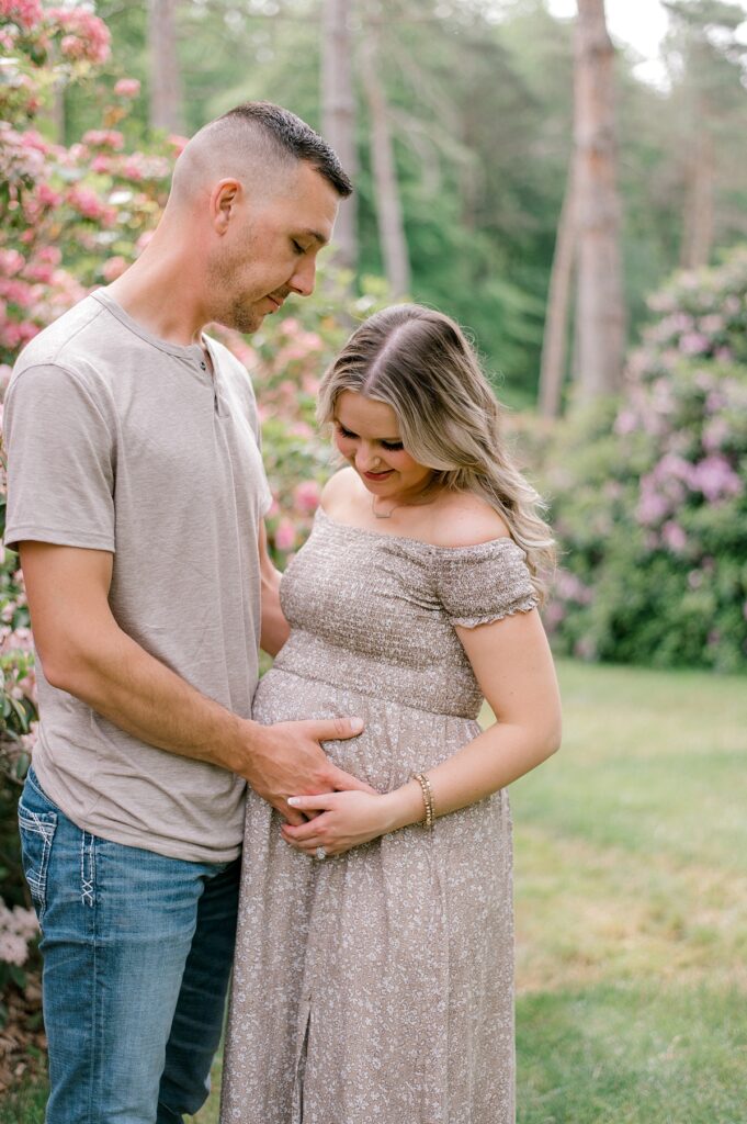 Expecting parents holding pregnant mother's belly in neutral beige and tan clothing at Schoepfle Gardens by maternity photographer Brittany Serowski Photography.