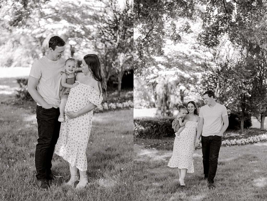 A family of three walking through Schoepfle Gardens smiling at each other by maternity photography Brittany Serowski Photography.