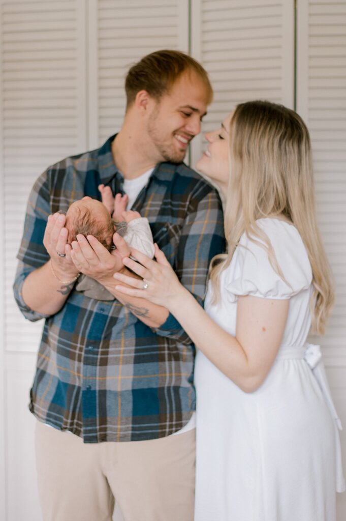 A mom and dad nuzzled close toby Parma newborn photographer, Brittany Serowski Photography.