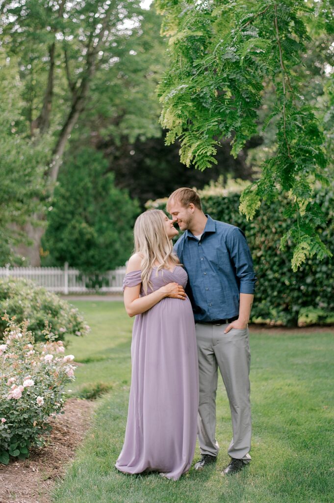 Vermilion Maternity Photography Session at Schoepfle Gardens by Brittany Serowski Photography. New expecting parents standing close together, nuzzled nose to nose in a garden.