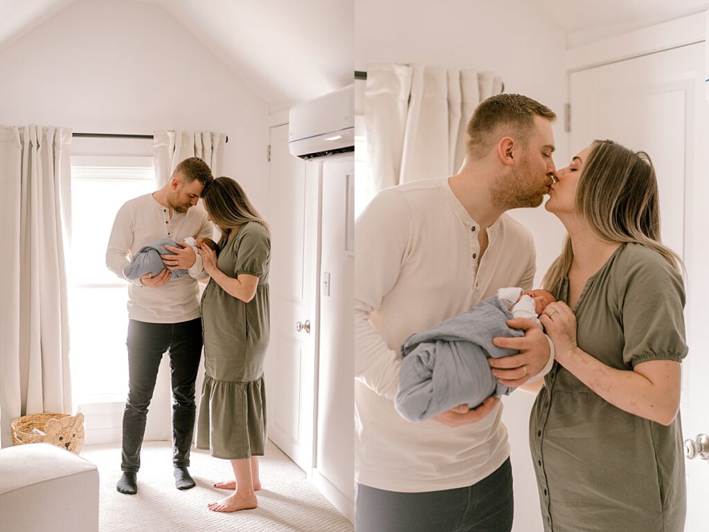 A mom and dad huddled close together in front of a large natural light window, with the curtain shades open in their son's nursery as the hold and view their newborn son. A great example of how to prepare your home for portraits.Mom and dad are in neutral clothes. Photographed by Cleveland newborn photographer, Brittany Serowski Photography.