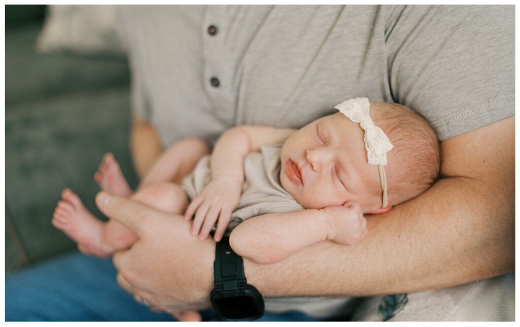 Soft newborn portrait of dad holding his newborn daughter in his arms, in a neutral palette in Cleveland. Documented by Cleveland Newborn Photographer, Brittany Serowski Photography.